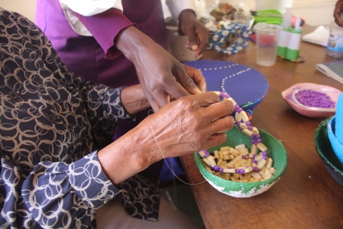 making beads necklaces from jacaranda seeds. Pic by Chris Tabvura